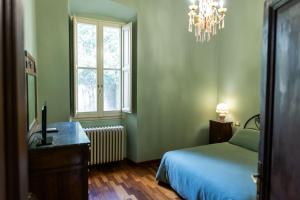 1 dormitorio con cama, escritorio y ventana en Palazzo Crescimbeni en Bevagna