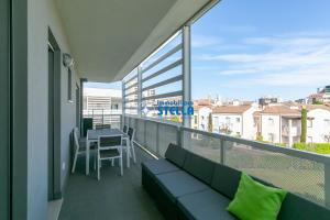 a balcony with a couch and a table with a view at Laguna Park in Lido di Jesolo