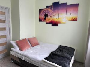 Pokój z łóżkiem z czterema obrazami na ścianie w obiekcie Apartament NATURA z widokiem na jezioro w Iławie
