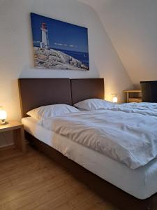 a bedroom with a bed with a picture of a lighthouse at St. Jobser Hof in Würselen