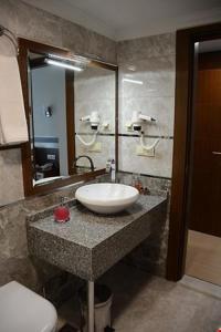 y baño con lavabo, aseo y espejo. en Hotel Avci, en Bulancak