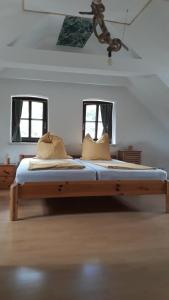 un grande letto in una stanza con due finestre di FeWo EselGlück Wälder Berge Seen Ruhe Naturidylle zw Bautzen Zittau Görlitz - Oberlausitz a Melaune