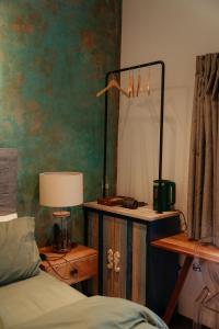 ein Schlafzimmer mit einem Bett und einem Tisch mit einer Lampe in der Unterkunft House Of Lens in Buon Ma Thuot