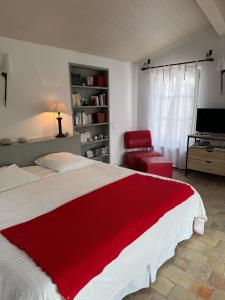 a bedroom with a large bed with a red blanket at Ma Chambre d'Amis in Saint-Clément-des-Baleines