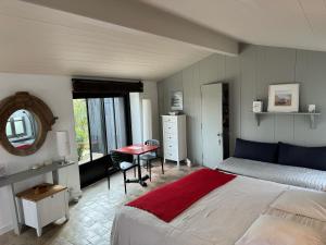 a bedroom with a bed and a table and a mirror at Ma Chambre d'Amis in Saint-Clément-des-Baleines