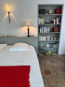 a bedroom with a bed with a red rug on it at Ma Chambre d'Amis in Saint-Clément-des-Baleines