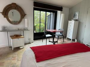 a bedroom with a bed and a desk and a red rug at Ma Chambre d'Amis in Saint-Clément-des-Baleines