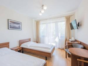 a hotel room with two beds and a window at WIKI Mrzeżyno in Mrzeżyno