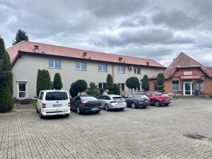 un gruppo di auto parcheggiate in un parcheggio di fronte a una casa di KARAT a Malbork