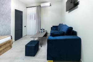 a living room with a blue couch and a table at EVN Rooms in Yerevan