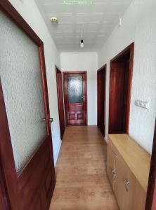 an empty hallway with two doors and a wooden floor at Vila FH in Ilijaš