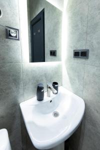a white sink in a bathroom with a mirror at EVN Rooms in Yerevan