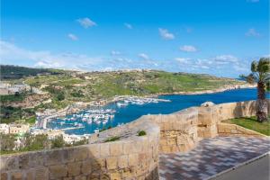 uma vista para um porto a partir da parede de uma fortaleza em Harbour Views Gozitan Villa Shared Pool - Happy Rentals em Mġarr