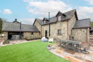 a stone house with a lawn in front of it at Barraston Farm Country Retreat in Balmore