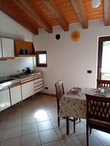 a kitchen with a table and chairs in a room at La Colombara in Fara Vicentino