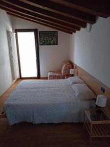 a bedroom with a large bed and a window at La Colombara in Fara Vicentino
