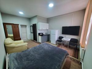 BăcioiにあるARMONIE AIRPORT HOSTELのベッド、デスク、テレビが備わる小さな客室です。