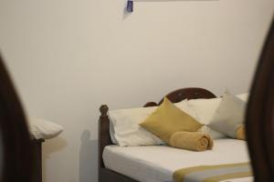 a bedroom with a bed with white pillows at Xotic Resort Upper Floor in Kurunegala