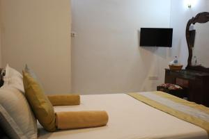 a bedroom with a bed and a tv on the wall at Xotic Resort Upper Floor in Kurunegala
