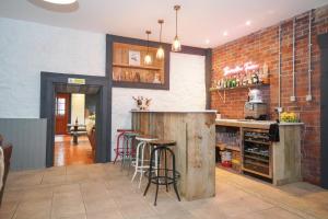 a kitchen with a bar with stools and a brick wall at Barraston Farm Country Retreat in Balmore