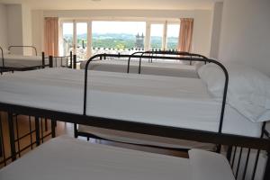 two bunk beds in a room with a window at Albergue Internacional in Sarria