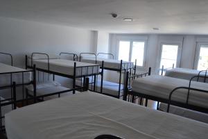 een kamer met meerdere stapelbedden en ramen bij Albergue Internacional in Sarria