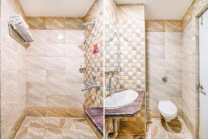 a bathroom with a sink and a toilet at FabHotel Jansi Deluxe Gandhipuram in Coimbatore