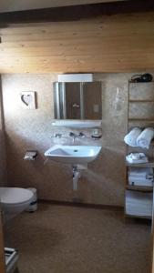 uma casa de banho com um lavatório e um WC em Augustin Oswald em Müstair