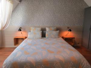 um quarto com uma cama grande com edredão azul e laranja em Le Gîte du Coin - Maison de vacances avec jardin em Le Bocasse