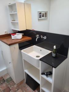 a bathroom with a white sink and a black counter at Ma Chambre d'Amis in Saint-Clément-des-Baleines