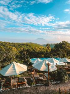 a group of umbrellas and chairs with a view at Penida Bambu Green in Nusa Penida