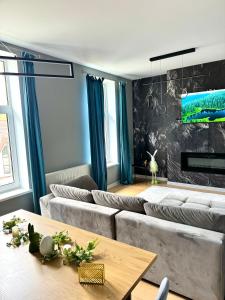 ein Wohnzimmer mit Sofas und einem Tisch in der Unterkunft LV Luxury Apart - One minute away from train station in Predeal