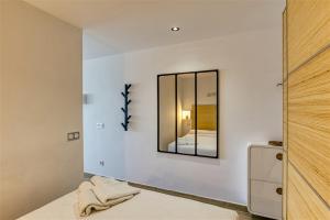 1 dormitorio con espejo en la pared en Sea-CHIC Appartement, en Empuriabrava