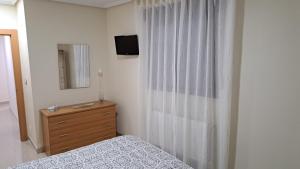 1 dormitorio con cama, tocador y espejo en Apartamento Romero en Caravaca de la Cruz