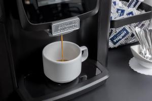 a cup of coffee with a sign in a coffee machine at Maj Luxury Residence in Poreč