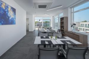 a dining room with tables and chairs and large windows at Maj Luxury Residence in Poreč