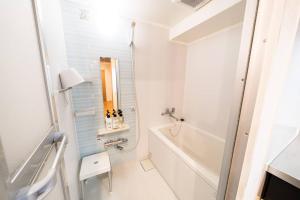 a white bathroom with a tub and a sink at Shibuya sta 3min・center area・Switch・Pocket Wi-Fi in Tokyo +26 photos