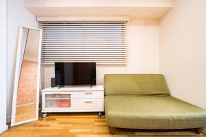a living room with a couch and a television at Shibuya sta 3min・center area・Switch・Pocket Wi-Fi in Tokyo