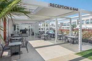 an outdoor patio with tables and chairs and a restaurant at Maj Luxury Residence in Poreč