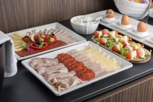a buffet with three trays of food on a table at Maj Luxury Residence in Poreč