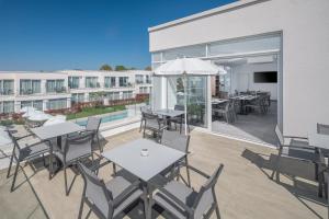 a patio with tables and chairs and a building at Maj Luxury Residence in Poreč