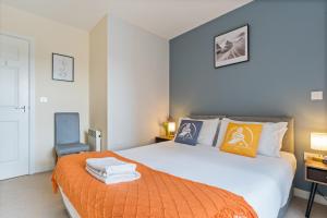 - une chambre avec un grand lit et une couverture orange dans l'établissement 247 Serviced Accommodation in Telford 2 BR Apartment, à Telford