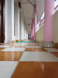 an empty hallway with pink and white columns in a building at Amaravathi hotel and restaurant in Port Blair