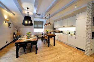 a kitchen and dining room with a table and chairs at Apartament Mazowiecka 3 in Niechorze