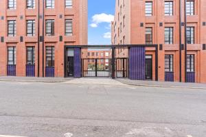 uma rua vazia em frente a um grande edifício de tijolos em Birmingham City Centre Serviced Apartment - Celestial Lettings em Birmingham