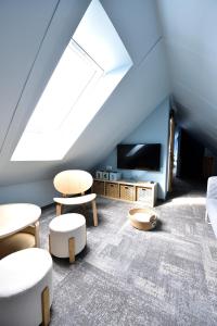 a attic room with tables and chairs and a tv at Apartament Mazowiecka 3 in Niechorze