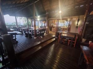 Habitación con suelo de madera, mesas y sillas. en Ndiza Lodge and Cabanas, en St Lucia