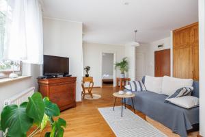 a living room with a blue couch and a tv at Lapwing Apartments - Comfort in Sopot