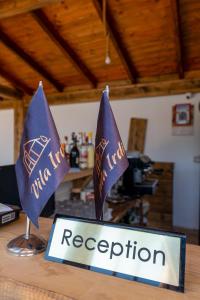 two flags on a table with a registration sign at Vila Irdi in Ksamil