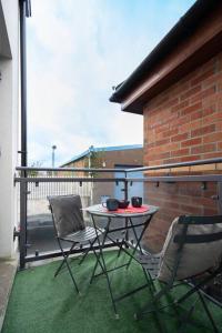 d'une terrasse avec une table et deux chaises sur un balcon. dans l'établissement Stylish Unique 2 Bedroom Duplex With a Balcony & Free City Parking, à Belfast